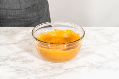 Sıcak bir mutfakta, büyük bir karıştırma kabı malzemelerin ustalıkla harmanlanması için sahne olur, kek karışımından nefis bir ev yapımı balkabağı pastası hazırlamak için sahne hazırlar.