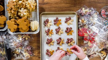 Düz yatıyordu. Dikkatlice paketlenmiş Noel kurabiyeleri, çikolataya batırılmış, ezilmiş fındık serpiştirilmiş, ve şeffaf selofan ambalajla sunulmuş..