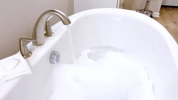 Elegante Weiße Badewanne Gefüllt Mit Wasser Mit Einem Eleganten Gebürsteten Stockbild