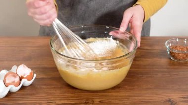 Bardak karıştırma kabında, büyük bir el çırpma ustalıkla lezzetli zencefilli kek ve karamel kremalı pasta malzemelerini karıştırır..