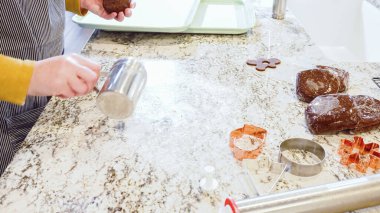 Modern bir mutfaktaki zarif mermer tezgahın üzerine zencefilli kurabiye hamuru sermek için ayarlanabilir bir merdane kullanmak, bayram pişirme şenliğine hazırlanmak....