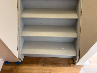 Bir banliyö evinin bodrumuna çıkan, ham madde ve inşaat sürecini gösteren bitmemiş bir merdivenin tipik yapısını keşfedin..