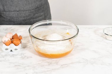 Sıcak bir mutfakta, büyük bir karıştırma kabı malzemelerin ustalıkla harmanlanması için sahne olur, kek karışımından nefis bir ev yapımı balkabağı pastası hazırlamak için sahne hazırlar.