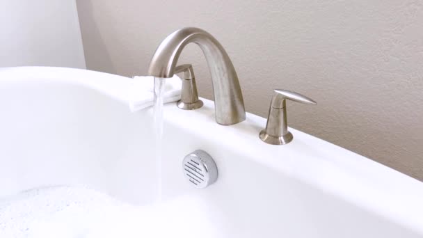 Elegant White Bathtub Filled Water Featuring Sleek Brushed Nickel Faucet — Stock Video