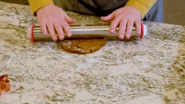 Çağdaş beyaz bir mutfakta zencefilli kurabiye hamuru ustalıkla sarılır ve nefis bir tatil ziyafeti için zemin hazırlar..