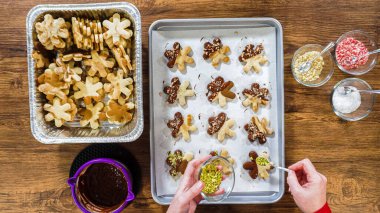 Düz yatıyordu. Çikolataya batırılmış ve farklı malzemelerle süslenmiş kar tanesi şeklindeki kesme şekerli kurabiyeler yaratmak..