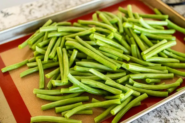 新鮮な緑の豆がシリコーンマットでベーキングシートに完璧にローストされ あなたの食事に味のバーストを加えるように見てください ストック画像