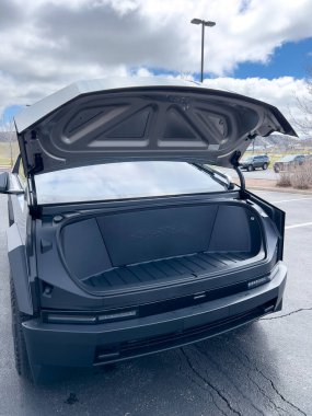 Denver, Colorado, ABD-28 Mart 2024-Tesla Cybertruck 'ın ön profili sergileniyor, fütüristik çizgileri ve sağlam tasarımı sergileniyor, açık hava parkında dinamik bir gökyüzü ile park edilmiş.