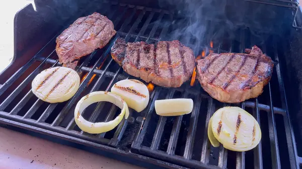 Ribeye Steaks Sizzling Alongside Golden Grilled Onions Barbecue Grill Wisps — Stock Photo, Image