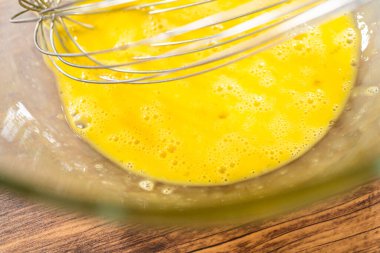 Bardak karıştırma kabında, büyük bir el çırpma ustalıkla lezzetli zencefilli kek ve karamel kremalı pasta malzemelerini karıştırır..