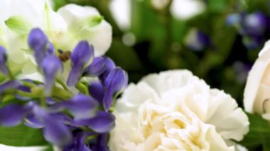 Taze beyaz güllerin ve çeşitli çiçeklerin bulunduğu büyüleyici bir buket, zarif bir vazoda düzenlenmiş, zamansız bir güzellik yayıyor..