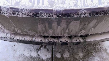 Bir Tesla Siber Traktörü, sabun köpüğüyle kaplanmış eşsiz ve açısal dış yüzeyi ile kapsamlı bir yıkamadan geçer. Aracın parlak tasarımı ve dayanıklı yüzeyleri ön plana çıkar..