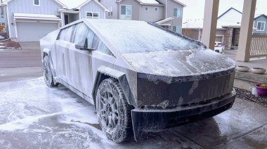 Bir Tesla Siber Traktörü, sabun köpüğüyle kaplanmış eşsiz ve açısal dış yüzeyi ile kapsamlı bir yıkamadan geçer. Aracın parlak tasarımı ve dayanıklı yüzeyleri ön plana çıkar..