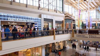 Denver, Colorado, USA-April 28, 2024- Capturing the expansive and airy interior of Park Meadows Mall, this image highlights the modern architectural style with wooden beams, large hanging lights, and clipart