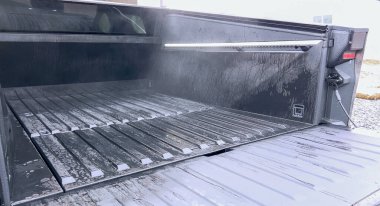 Denver, Colorado, ABD-28 Nisan 2024. Bu görüntü, kargo yatağının yüksek basınçlı yıkanmasına odaklanarak, bir Tesla Cybertruck 'ın kapsamlı bir temizlik sürecini yakalar.