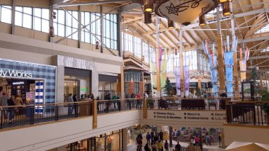 Denver, Colorado, USA-April 28, 2024- Capturing the expansive and airy interior of Park Meadows Mall, this image highlights the modern architectural style with wooden beams, large hanging lights, and clipart