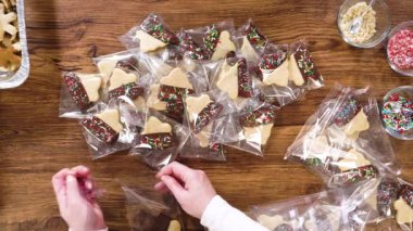 Düz yatıyordu. Dikkatlice paketlenmiş Noel kurabiyeleri, çikolataya batırılmış ve şeffaf selofan ambalajla sunulmuş, bayram hediyesi olarak mükemmel..