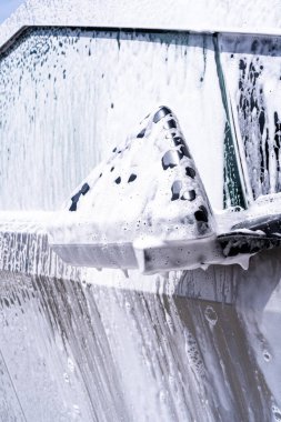 Denver, Colorado, ABD-5 Mayıs 2024 Bu görüntü, bir araba yıkama sırasında sabun köpüğüyle kaplanmış Tesla Siber Kamyon yan aynasının yakın görüntüsünü yakalıyor.