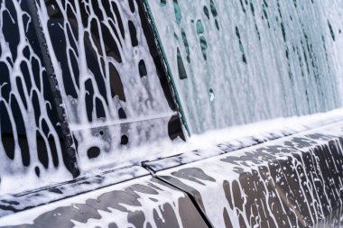 Denver, Colorado, ABD-5 Mayıs 2024. Bir araba yıkama sırasında sabun köpüğüyle kaplanmış bir Tesla Siber Kamyonu 'nun yakın çekim görüntüsü açısal yüzeyinde akan desenleri gösteriyor ve benzersiz görüntüyü vurguluyor.