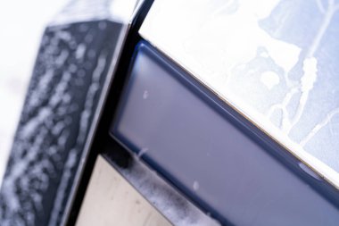 Denver, Colorado, ABD-5 Mayıs 2024-Bu görüntü, sabun köpükleri ve su ile vurgulanmış, vücudun pencereyle buluştuğu kenarı gösteren, Tesla Siber Kamyonu 'nun parlak dış görünüşünü detaylı bir şekilde yakalıyor.