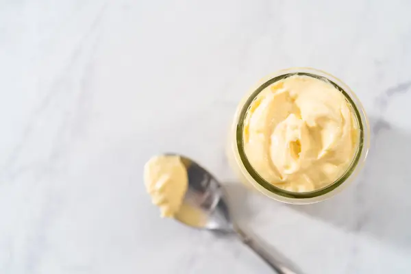 stock image Cream cheese filling for bundt cake in small glass jat.