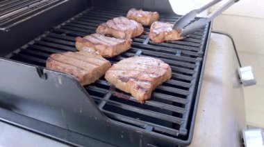 Üç parlak, terbiye edilmiş somon filetosu sıcak ızgarada eşit derecede pişirilir. Lezzetli bir yemek vaad eden canlı renk ve cızırtılı seslerle vurgulanır..