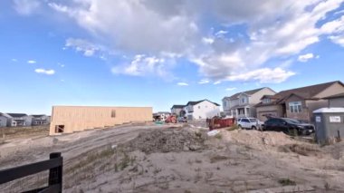 Denver, Colorado, ABD-30 Ağustos 2023-Timelapse yeni bir yerleşim yerinin ham ahşap çerçeve ve tamamlanmış evler arasındaki katı zıtlığı ortaya koyuyor