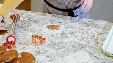 Modern bir mutfaktaki zarif mermer tezgahın üzerine zencefilli kurabiye hamuru sermek için ayarlanabilir bir merdane kullanmak, bayram pişirme şenliğine hazırlanmak....