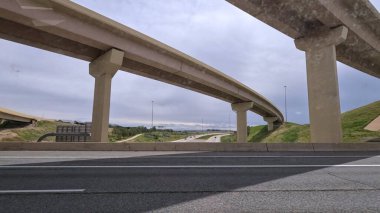 Güney Denver 'daki yükseltilmiş otoyol üst geçidinin dinamik görüntüsü, karmaşık beton yapıları ve modern yol tasarımını gözler önüne seriyor. Görüntü geniş şeritleri ve çevresindeki manzarayı yakalar.