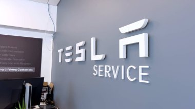 Colorado Springs, Colorado, ABD-12 Haziran 2024 Tesla Servis Merkezi tabelasının gri bir duvardaki yavaş çekim görüntüsü Tesla 'nın araç bakım ve onarım yerini gösteriyor. Şık ve modern.