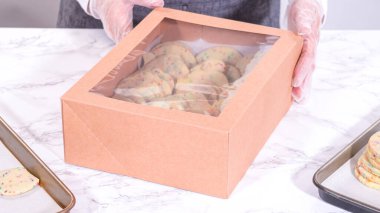 Hamurun içine şeker parçacıkları doldurulmuş olan kurabiyeler, özenle özenle hazırlanmış, kırsal kahverengi bir karton kutuya konur..