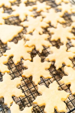 Lezzetli kar tanesi şekilli şekerli kurabiyeleri rafta soğutup onları Noel hediyelerine hazırlıyorum..