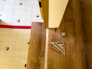 Bu resim bir alt katman üzerine yeni lamine döşeme işlemini betimler. Kısmen döşenmiş lamine kalaslar ve alt katman şebekesinin yapısı açıkça görülüyor.