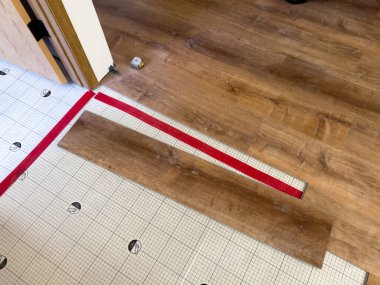 Bu resim bir alt katman üzerine yeni lamine döşeme işlemini betimler. Kısmen döşenmiş lamine kalaslar ve alt katman şebekesinin yapısı açıkça görülüyor.