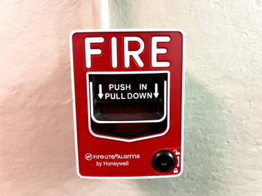 Denver, Colorado, ABD-12 Temmuz 2024 - Görüntü, bir duvara monte edilmiş kırmızı bir yangın alarmının yakın çekim görüntüsünü gösteriyor. Yangın alarmı, Honeywell tarafından, açıkça talimatları gösterir