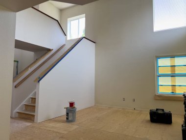 Broomfield, Colorado, ABD-14 Temmuz 2024 - Görüntü, yeni döşemeler için hazırlanmış bir merdiven ve geniş bir odanın yer değiştirdiği bir ev yenileme projesi gösteriyor.