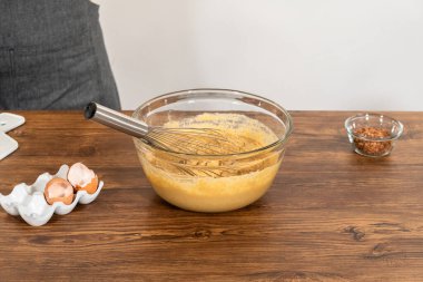 Bardak karıştırma kabında, büyük bir el çırpma ustalıkla lezzetli zencefilli kek ve karamel kremalı pasta malzemelerini karıştırır..