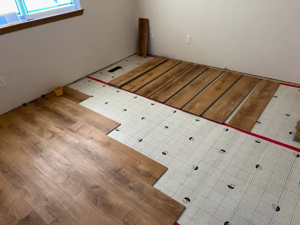 stock image Broomfield, Colorado, USA-July 7, 2024-Progress shot of installing vinyl plank flooring over underlayment. The underlayment is in place, and several vinyl planks are partially laid out, demonstrating