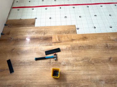 Süpürge Sahası, Colorado, ABD-7 Temmuz 2024-İlerleme aşaması. Alttan döşeme üzerine vinil döşeme montajı. Yeraltı tabakası yerinde, ve bazı vinil levhalar kısmen serilmiş,