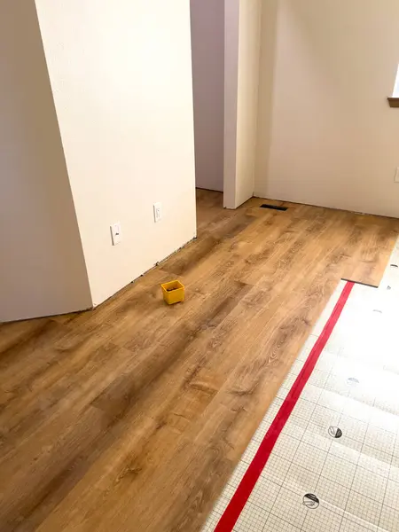 stock image Broomfield, Colorado, USA-July 6, 2024-Image depicting a home flooring renovation in progress, showcasing the transition from underlayment to wood laminate. The wooden laminate flooring is partially