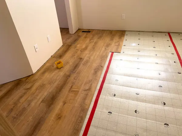 stock image Broomfield, Colorado, USA-July 6, 2024-Image depicting a home flooring renovation in progress, showcasing the transition from underlayment to wood laminate. The wooden laminate flooring is partially