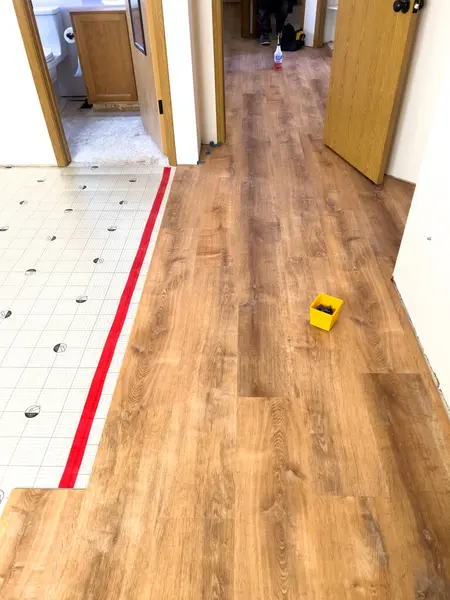 stock image Broomfield, Colorado, USA-July 6, 2024-Image depicting a home flooring renovation in progress, showcasing the transition from underlayment to wood laminate. The wooden laminate flooring is partially