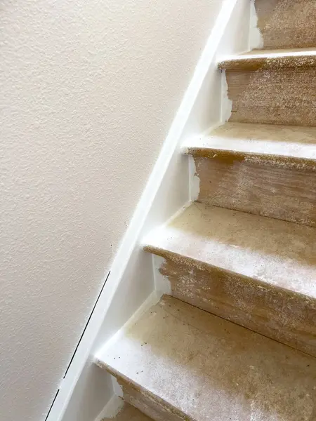 stock image Close-up image showing the progress of wood laminate flooring installation on a staircase landing. The top step is covered with new laminate flooring, while the lower steps and surrounding area show