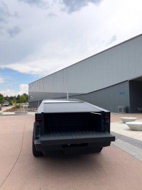 Denver, Colorado, ABD-17 Temmuz 2024 Sek Tesla Cybertruck bulutlu bir gökyüzünün arka planına park edilmiş durumda. Elektrikli aracın fütüristik, açısal tasarımı doğal olarak göze çarpıyor.