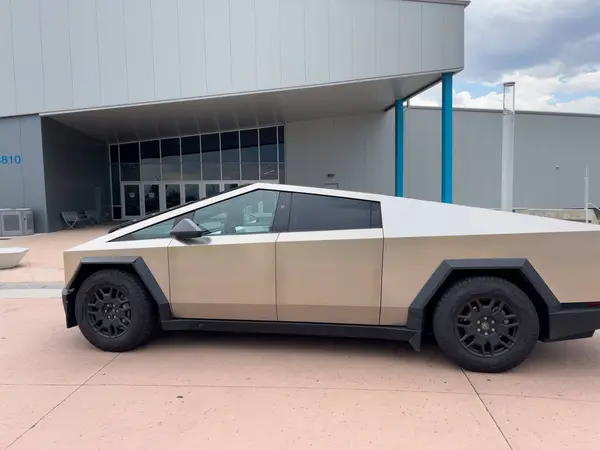 stock image Denver, Colorado, USA-July 17, 2024-A sleek Tesla Cybertruck is parked outdoors against a backdrop of a cloudy sky. The futuristic, angular design of the electric vehicle stands out in the natural