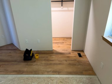 Süpürge, Colorado, ABD-6 Temmuz 2024 döşeme döşeme işleminin detaylı bir görüntüsü, şebeke desenli bir altyapının üzerine döşenmiş ahşap kaplama döşemesini gösteriyor. Yeraltı güvenliği sağlandı.