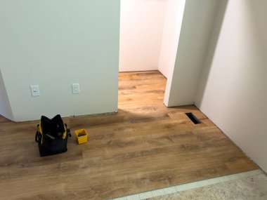 Süpürge, Colorado, ABD-6 Temmuz 2024 döşeme döşeme işleminin detaylı bir görüntüsü, şebeke desenli bir altyapının üzerine döşenmiş ahşap kaplama döşemesini gösteriyor. Yeraltı güvenliği sağlandı.