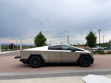 Denver, Colorado, ABD-17 Temmuz 2024 Sek Tesla Cybertruck bulutlu bir gökyüzünün arka planına park edilmiş durumda. Elektrikli aracın fütüristik, açısal tasarımı doğal olarak göze çarpıyor.