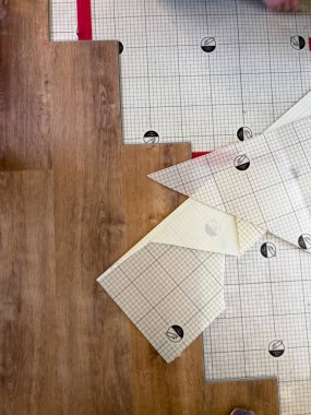 Süpürge, Colorado, ABD-6 Temmuz 2024 döşeme döşeme işleminin detaylı bir görüntüsü, şebeke desenli bir altyapının üzerine döşenmiş ahşap kaplama döşemesini gösteriyor. Yeraltı güvenliği sağlandı.