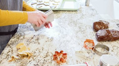 Modern bir mutfaktaki zarif mermer tezgahın üzerine zencefilli kurabiye hamuru sermek için ayarlanabilir bir merdane kullanmak, bayram pişirme şenliğine hazırlanmak....